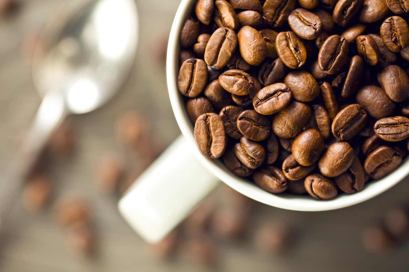 Roasted coffee beans in a cup, viewed from above